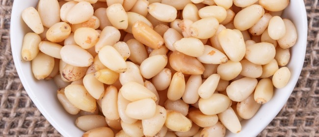 pine nuts in cup in the shape of heart on sack cloth